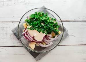 Mišrainę pagardinkite majonezu, įdėkite smulkiai pjaustyto laiškinio svogūno ir gerai išmaišykite.