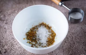 Į atskirą dubenėlį sudėkite druską ir įmaišykite prieskonių mišinį.