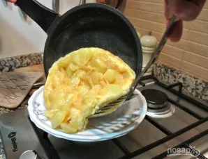 Atsargiai pakelkite kraštus mentele, kai omleto vidus dar likęs skystas. Išverskite ant lėkštės.