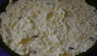 Į varškę sudėkite obuolius ir razinas ir vėl išmaišykite. Kepimo skardą išklokite kepimo popieriumi ir supilkite į ją varškės tešlą.