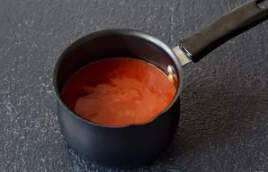 Į prikaistuvį supilkite vandenį ir pomidorų pastą. Virkite padažą ant vidutinės ugnies, nuolat maišydami šluotele, kol sutirštės. Pasūdyk...