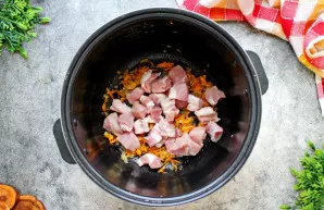 Kiaulieną supjaustykite vidutinio dydžio kubeliais ir sudėkite prie daržovių. Kepinkite tuo pačiu režimu 10-15 minučių neuždengę dangčio....