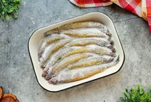 Iš viršaus apibarstykite žuvį druska.