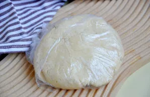 Rankomis užminkykite tešlą, ilgai minkyti nereikia, tiesiog sujunkite tešlą į gumulą. Tešlą suvyniokite į plėvelę ir padėkite į šaldytuvą...