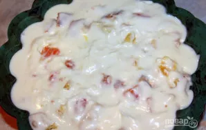 Į formos dugną supilkite pusę kremo, įmerkite pusę supjaustyto biskvito ir supjaustytų vaisių, tada vėl kremą ir biskvitą su vaisiais.