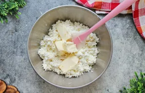 Į varškę įdėkite minkštą sviestą. Išmaišykite iki vientisos masės.