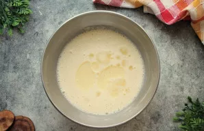 Į tešlą įpilkite augalinio aliejaus ir dar kartą išmaišykite. Uždenkite dubenį rankšluosčiu ir palikite 15-20 minučių pastovėti.