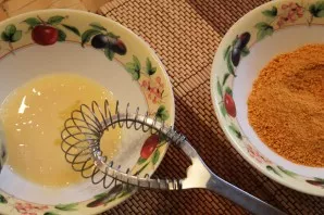 Išplakite kiaušinį ir pamirkykite jame kotletus. Tada apvoliokite juos džiūvėsėliuose.
