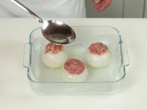 Įdarytus svogūnus sudėkite į formą ir užpilkite sultiniu.