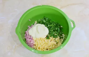 Įdėkite smulkiai supjaustytų žalumynų ir majonezo. Viską gerai išmaišykite.