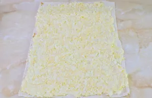 Ant stalo ištieskite lavašą. Ant jo tolygiai paskleiskite paruoštą įdarą plonu sluoksniu.