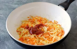 Tada sudėkite pomidorų pastą ir troškinkite dar 2–3 minutes.