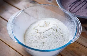 Į kitą dubenį persijokite miltus.