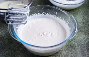 Į didelį dubenį supilkite atšaldytą grietinėlę ir plakite mikseriu iki kreminės konsistencijos, t. y. iki minkštų putų.