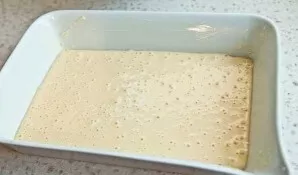 Karščiui atsparią kepimo formą gerai ištepkite sviestu. Ant dugno supilkite šiek tiek tešlos.