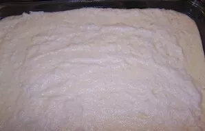 Kepimo indą ištepkite sviestu ir pabarstykite manų kruopomis (galite iškloti kepimo popieriumi). Paskleiskite varškės mišinį ir išlyginki...