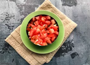 Pomidorus supjaustykite kubeliais, sudėkite ir pasūdykite.