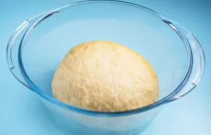 Užminkykite minkštą tešlą, kuri nelimpa prie rankų. Tešlą suformuokite į rutulį dubenyje, dubenį uždenkite virtuviniu rankšluosčiu ir pal...