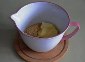 Į sausainių trupinius įdėkite minkšto sviesto, sumaišykite rankomis — masė turi sudrėkti ir nekristi per pirštus.