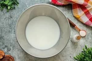 Į dubenį supilkite šiltą pieną, įberkite druskos ir cukraus, maišykite, kol ištirps kristalai.