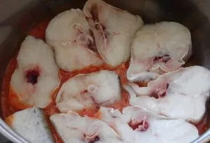 Sudėkite menkę į puodą. Sluoksniuokite, pakaitomis su padažu.
