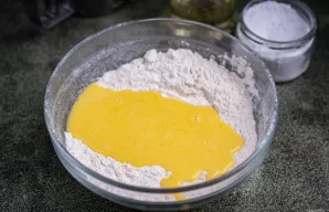 Į miltų sausą mišinį supilkite skystą kiaušinių masę.