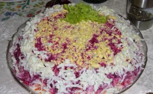 Viršų papuošiame tarkuotais tryniais ir likusiais baltymais. Prieš patiekiant, salotas kelioms valandoms padėkite į šaldytuvą. Skanaus!