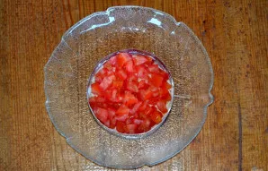 Pomidorą perpjaukite pusiau, išimkite vidų, kad nebūtų sulčių. Minkštimą supjaustykite kubeliais ir sudėkite lygų sluoksnį.