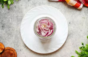 Supjaustytus svogūnus sudėkite į švarų, sausą stiklainį, nesuspausdami. Užpilkite svogūnus marinatu, uždarykite dangteliu ir padėkite į š...