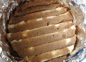 Pradedame rinkti tiramisu: dugną ištepkite kremu. Perpjautą biskvitą pamirkykite kavos ir likerio mišinyje. Tada dėkite jį ant kremo.