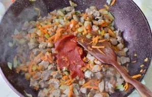 Į mėsą įdėkite pomidorų pastos. Pagardinkite druska ir prieskoniais pagal skonį.