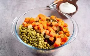 Sudėkite ten morkų kubelius ir agurkus.