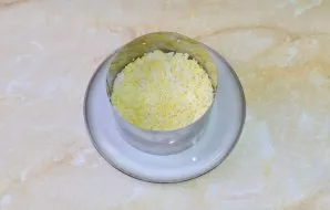 Sutarkuokite virtus kiaušinius ir sudėkite juos kaip kitą salotų sluoksnį.