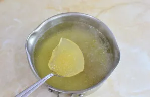 Iš sultinio išimkite vištą. Patį sultinį perkoškite ir įmaišykite išbrinkusią želatiną, maišykite, kol visiškai ištirps.