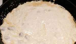 Į troškintas širdeles įpilkite grietinėlės ir užvirinkite, maišydami.