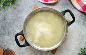 Sumažinkite ugnį ir į sriubą sudėkite lydytą sūrį. Virkite ant silpnos ugnies, maišydami, kol sūris visiškai ištirps.