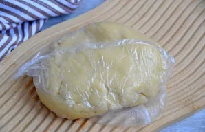 Suformuokite tešlą į rutulį, suvyniokite į plėvelę ir padėkite į šaldytuvą tol, kol ruošite įdarą.