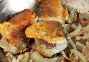 Kai žuvis taps auksinės rudos spalvos, sudėkite svogūną, supjaustytą pusžiedžiais arba žiedais. Kepkite, kol suminkštės. Jūsų kepta žuvis...