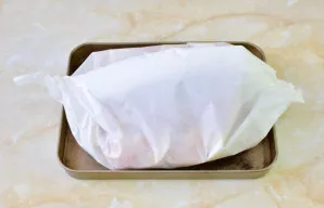 Apvyniokite mėsą pergamentu arba folija. Dėkite į orkaitę ir kepkite apie 1,5 valandos 180 °C temperatūroje. Kepimo pabaigoje mėsą atiden...