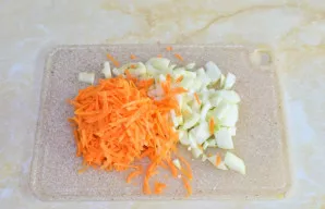 Nulupkite ir susmulkinkite svogūną bei morką. Svogūną supjaustykite, o morką sutarkuokite.