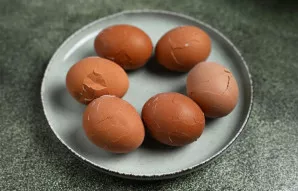 Kiaušiniai jau išvirė - išimkite juos į lėkštę ir lengvai patrankykite šaukštu, kad lukšte atsirastų smulkių įtrūkimų.