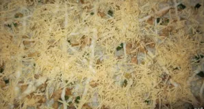 Iš viršaus pabarstykite tarkuotu sūriu - šiek tiek palikite dar vyniotinio viršui apibarstyti.