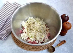 Į dubenį sudėkite paruoštą kiaulieną ir svogūną, pagal skonį pasūdykite ir pagardinkite pipirais. Įdėkite zirą - prieš berdami ją į įdarą...