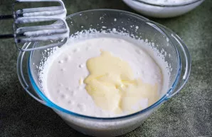 Į plakta grietinėlę įdėkite trynių ir cukraus mišinį bei vanilę.