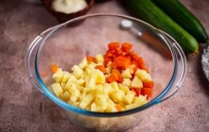 Į didelį dubenį sudėkite supjaustytas bulves ir morkas.