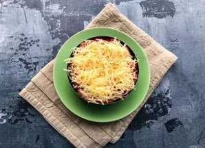 Sūrį sutarkuokite smulkia tarka ir uždėkite viršutiniu sluoksniu.