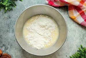 Į pieną įmuškite kiaušinius ir gerai išmaišykite.