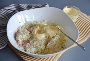 Į bendrą masę dėkite majonezą – po truputį, kol gausite tokią konsistenciją, kad iš jos būtų galima formuoti rutuliukus.