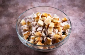 Išdžiovintus duonos skrebučius supjaustykite mažais kubeliais ir pridėkite prie salotų.