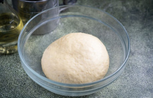 Užminkykite minkštą tešlą, suformuokite rutulį. Dubenį su tešla uždenkite virtuviniu rankšluosčiu ir pastatykite šiltoje vietoje 1 valandai.